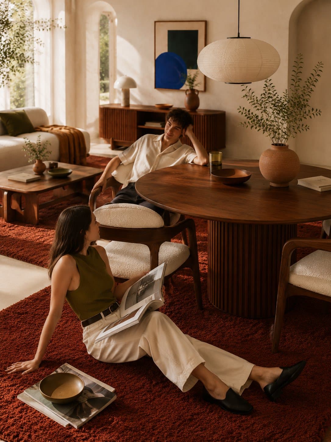 A woman on the rug beside the dining table, magazines fanned around her